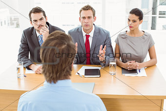 Business people interviewing man in office