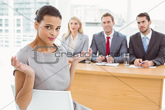 Woman sitting in front of corporate personnel officers