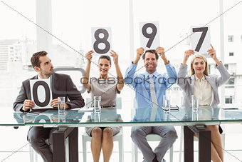 Interview panel holding score cards in office