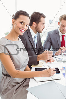Business people writing notes in board room meeting