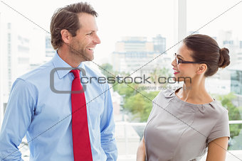 Business couple looking at each other in office