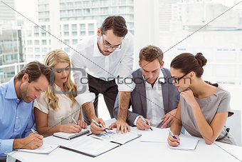 Executives writing notes in office