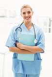 Smiling confident female doctor holding clipboard