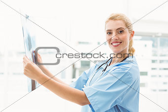 Smiling female doctor examining x-ray