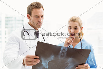 Male and female doctors examining x-ray