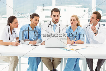 Male and female doctors using laptop