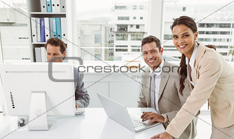 Business people using laptop and computer in office