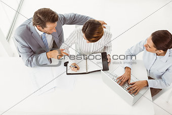 Business people with laptop and diary at office