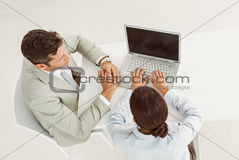 Business people using laptop in office