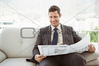 Businessman reading newspaper in living room