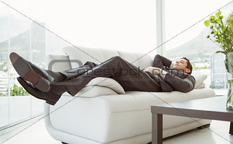 Young businessman lying on couch