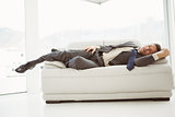 Businessman sleeping on couch in living room