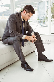 Worried businessman sitting on couch