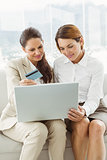 Happy young businesswomen doing online shopping