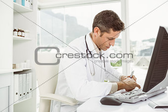 Doctor working at desk in medical office