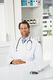 Smiling doctor sitting in medical office