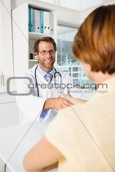 Doctor and patient shaking hands in medical office