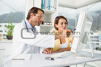 Doctor showing something on computer screen to patient