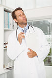 Thoughtful doctor with reports at medical office