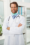 Male doctor with arms crossed in medical office