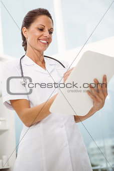 Female doctor holding clipboard in medical office