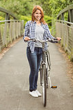Pretty redhead with her bike smiling at camera