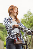 Readhead standing next to her bike with a camera
