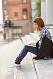 Young student using her laptop to study outside