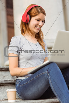 Happy enjoying woman listening with headphones to music