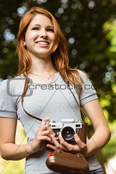 Pretty redhead holding her camera