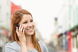 Smiling woman calling someone with her mobile phone