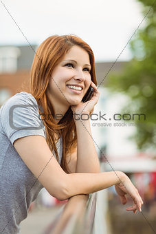 Pretty woman leaning on the bridge making a phone call