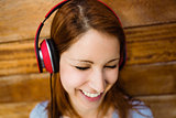 Natural smiling redhead listening to music with closed eyes