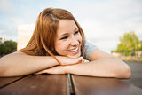 Smiling casual redhead lying on bench