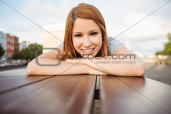 Portrait of a smiling redhead lying on bench