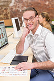 Smiling photo editors using computers in office