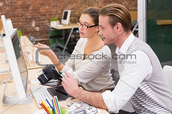 Concentrated casual photo editors using computer in office
