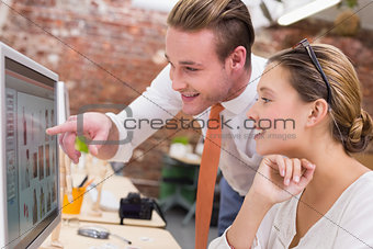 Photo editors looking at computer screen in office