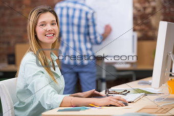 Happy female photo editor using computer in office
