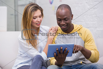 Casual business people using digital tablet on couch