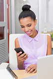 Businesswoman text messaging at office desk