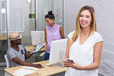 Casual woman with colleagues behind in office