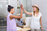 Colleagues high fiving in office