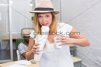 Casual woman holding disposable cups in office