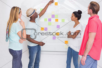 Creative team looking at sticky notes on wall