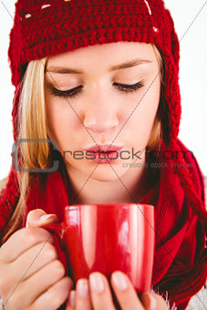 Festive blonde blowing over mug