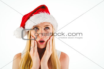 Festive blonde looking surprised with hands on face