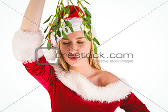 Festive cute blonde holding mistletoe