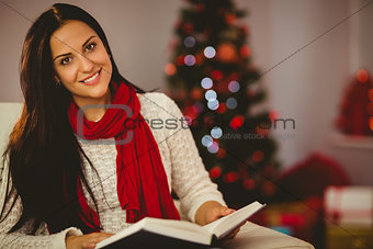 Pretty brunette reading on couch at christmas