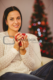 Pretty brunette relaxing on sofa at christmas